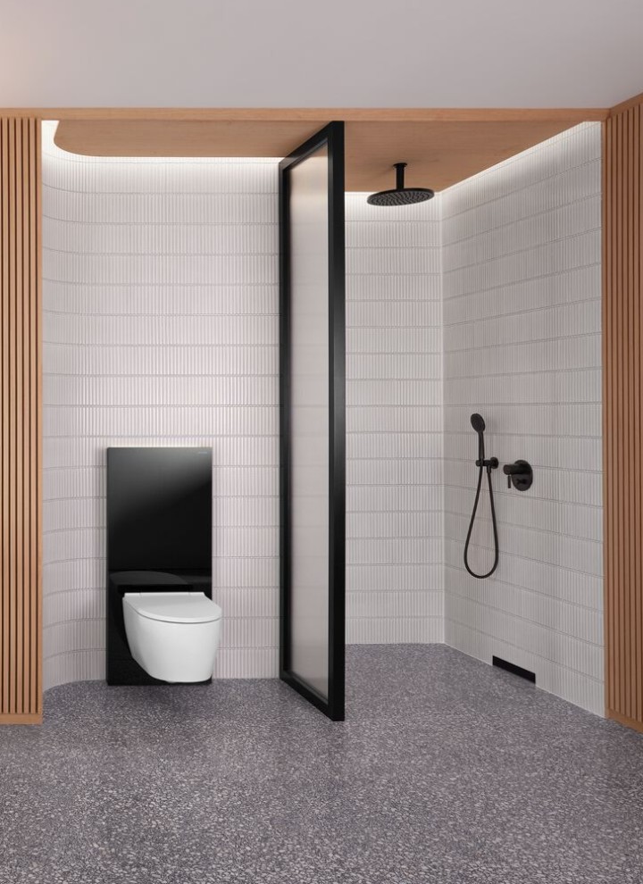 Kúpeľňa s drevenou stenou a so sprchovacím, umývadlovým a WC priestorom v čiernej a bielej farbe