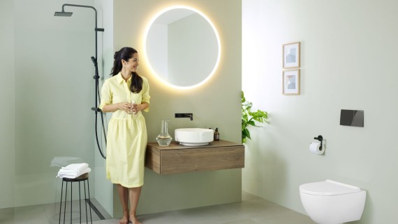 Žena v kúpeľni so zrkadlom Geberit Option a umývadlom Geberit VariForm