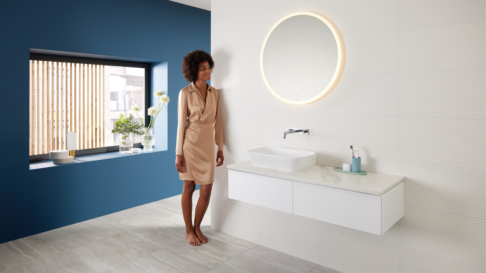 Woman standing in a bathroom created with the Mix & Match range from Geberit Woman standing in a bathroom created with the Mix & Match range from Geberit