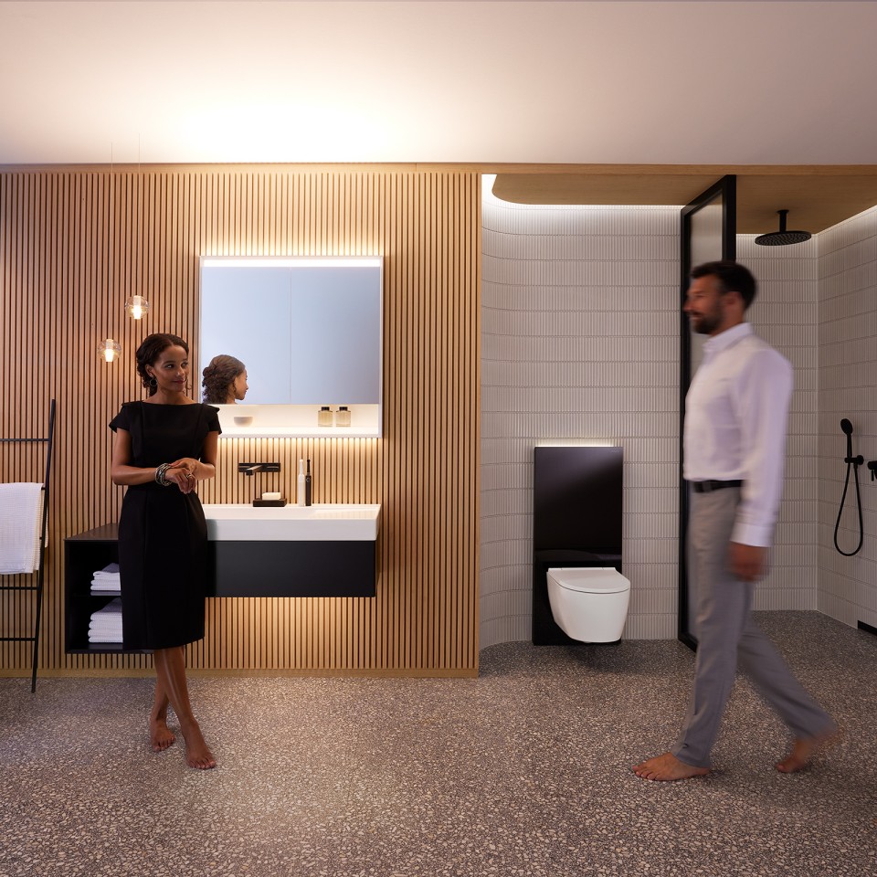 Muž a žena v dokonale nasvietenej kúpeľni s nábytkom a sanitou Geberit ONE (© Geberit)