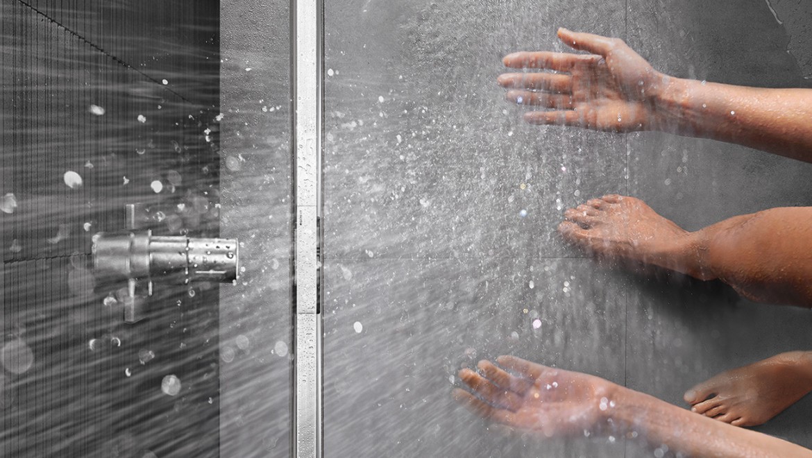 Osoba sprchujúca sa v sprche so sprchovým žľabom Geberit CleanLine v úrovni podlahy