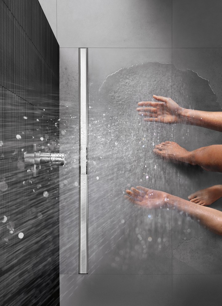 Osoba v sprche v úrovni podlahy so sprchovým žľabom CleanLine (© Geberit)