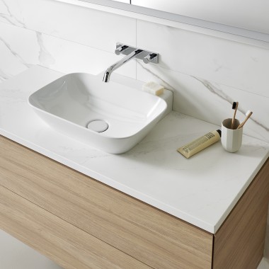 Umývací priestor s bielym umývadlom a drevenou kúpeľňovou skrinkou (© Geberit)