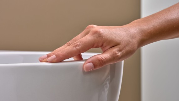 Ruka sa dotýka WC s povrchovou úpravou KeraTect®