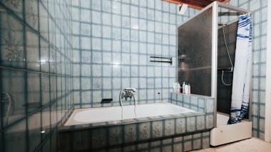 Kúpeľňa s modrou dlažbou, sprchovacím kútom a vaňou