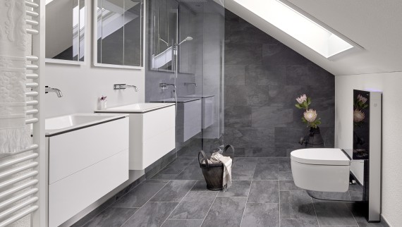Kúpeľňa so šikmým stropom a výrobky z kúpeľňovej série Geberit ONE a Geberit AquaClean s prvkom Monolith
