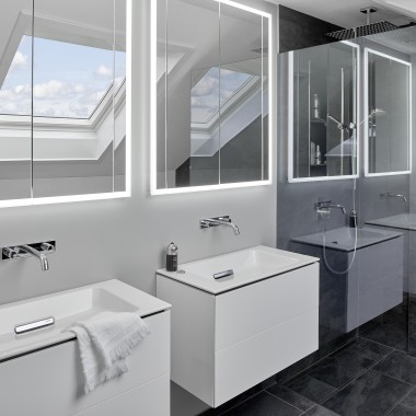 Kúpeľňa pod strechou s dvoma umývadlami a zrkadlami