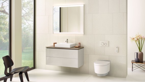Biela kúpeľňa so zrkadlovou skrinkou, umývadlovou skrinkou, ovládacím tlačidlom a keramickým zariadením Geberit