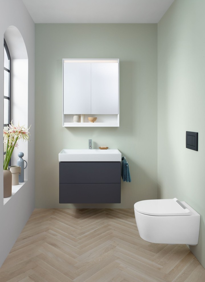 Pohľad na WC pre hostí so závesným WC, zrkadlovou skrinkou a umývadlovou skrinkou z kúpeľňovej série Geberit ONE