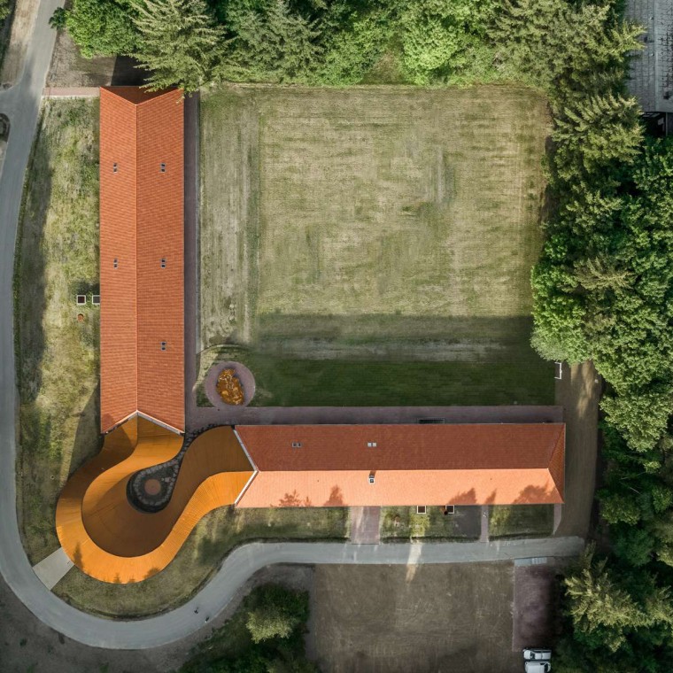 Pohľad zhora ukazuje okrúhlu novostavbu, ktorá spája dve historické budovy so škridlovými strechami (© R_Hjortshoj) Pohľad zhora ukazuje okrúhlu novostavbu, ktorá spája dve historické budovy so škridlovými strechami (© R_Hjortshoj)