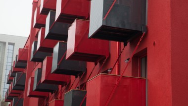 Nápadná červená fasáda s predsadenými kubickými balkónmi je novou dominantou ulice Goldsteinstrasse vo Frankfurte nad Mohanom (DE). (© Geberit)
