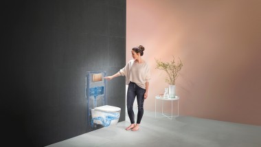 Žena spúšťa splachovanie na Geberit WC systéme (© Geberit)