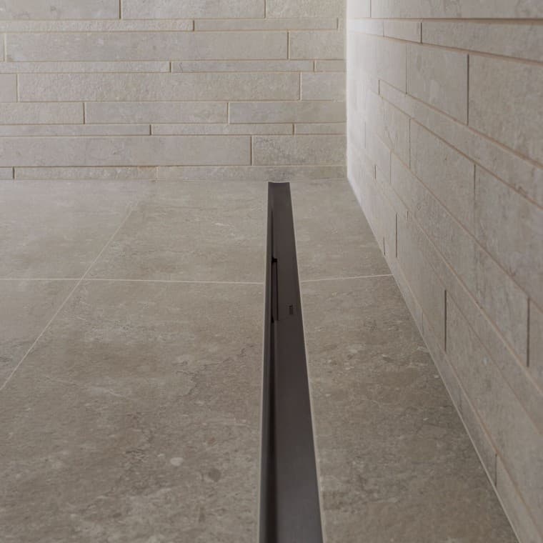 Voda odteká cez elegantný profil z ušľachtilej ocele. Voda odteká cez elegantný profil z ušľachtilej ocele.