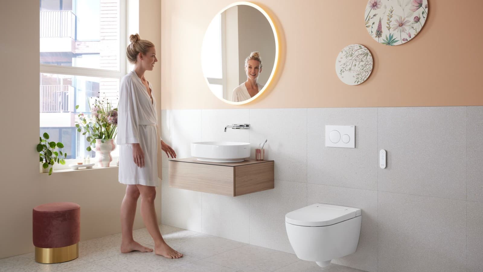 Žena v kúpeľni so sprchovacím WC Geberit AquaClean Alba Žena v kúpeľni so sprchovacím WC Geberit AquaClean Alba