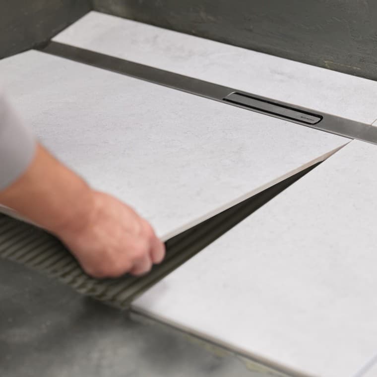 Drážky na sprchovom žľabe zabezpečujú pevné uchytenie v podlahe. Drážky na sprchovom žľabe zabezpečujú pevné uchytenie v podlahe.