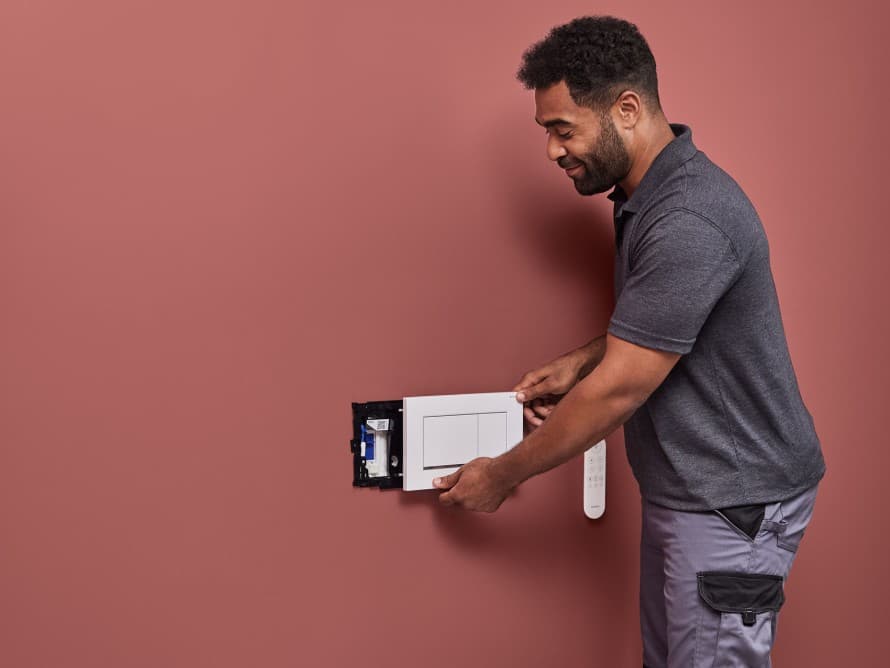 Muž inštaluje jednotku na odsávanie zápachu Geberit DuoFresh Muž inštaluje jednotku na odsávanie zápachu Geberit DuoFresh