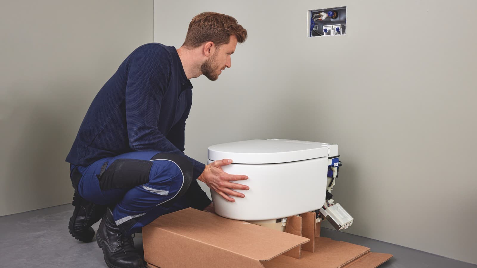Odborník v oblasti sanitárnej keramiky inštaluje sprchovacie WC Geberit AquaClean Sela Odborník v oblasti sanitárnej keramiky inštaluje sprchovacie WC Geberit AquaClean Sela